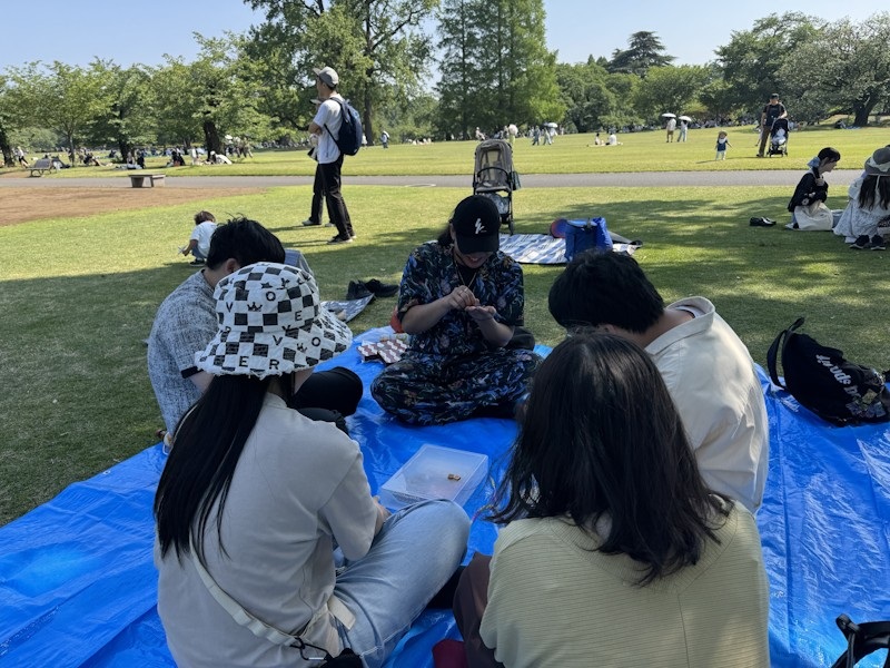新宿御苑で複数卓に分かれてごいたを遊んでいる様子